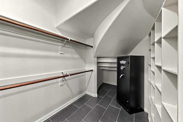 walk in closet with dark tile patterned floors