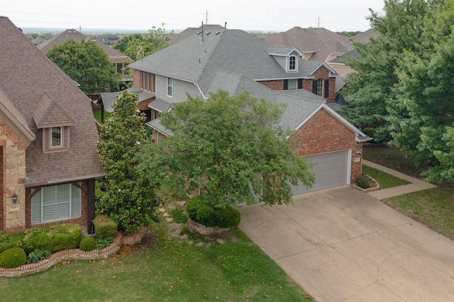 view of front of home featuring brick siding, a shingled roof, a front lawn, and a garage