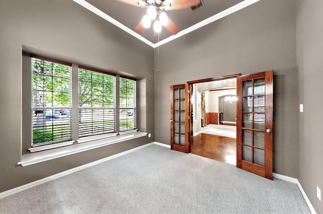 carpeted empty room with french doors, baseboards, crown molding, and visible vents