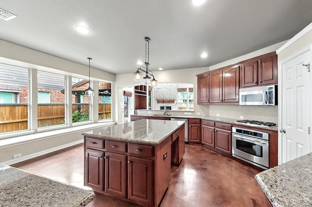 kitchen featuring concrete flooring, a sink, stainless steel appliances, a kitchen island, and visible vents