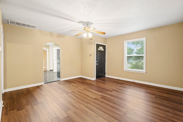 4416 Surrey St, Fort Worth, TX 76133 - empty room featuring arched walkways, a ceiling fan, wood finished floors, a textured ceiling, and baseboards