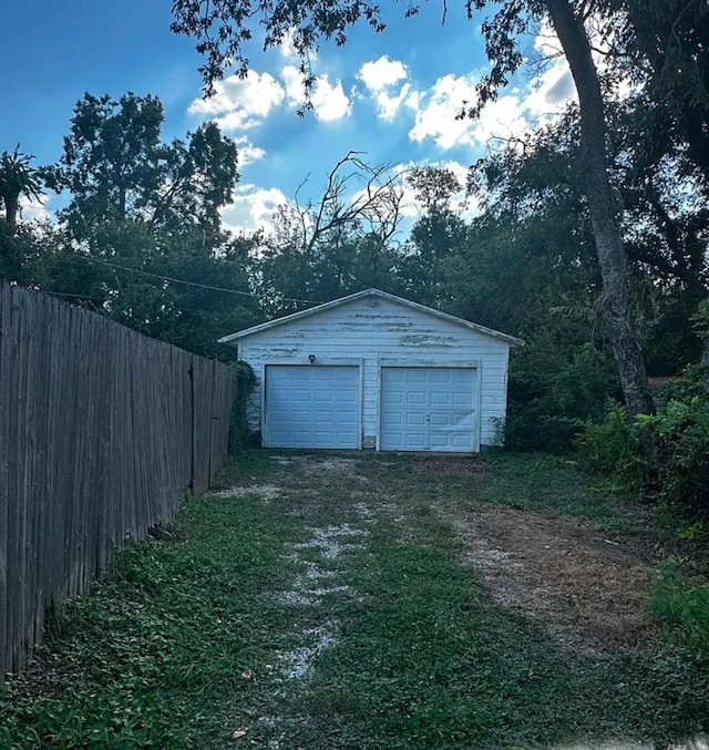 detached garage featuring fence
