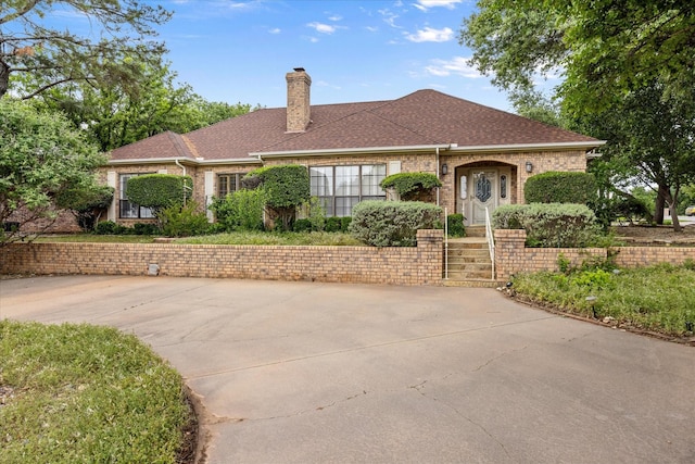 5311 Country Club Dr, Granbury, TX 76049 - view of front of home with a chimney, brick siding, and roof with shingles