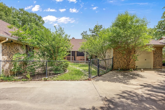 5311 Country Club Dr, Granbury, TX 76049 - view of property hidden behind natural elements featuring a gate, a garage, brick siding, driveway, and a shingled roof
