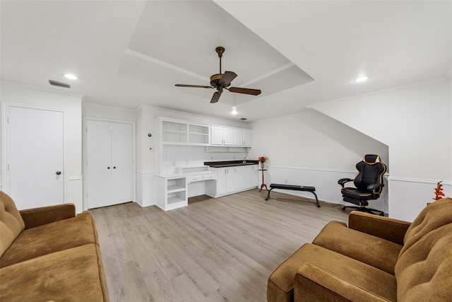 living room featuring visible vents, light wood-style floors, ceiling fan, recessed lighting, and a tray ceiling