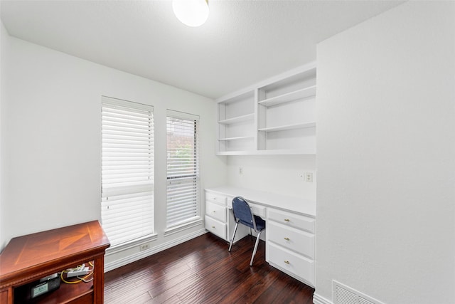 office featuring built in study area, baseboards, dark wood-style flooring, and visible vents
