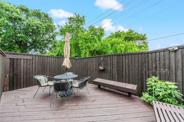 wooden deck featuring outdoor dining area and a fenced backyard