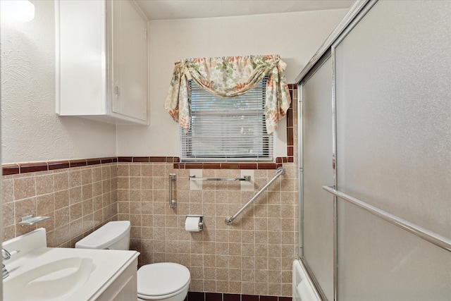605 Clebud Dr, Euless, TX 76040 - bathroom featuring toilet, tile walls, a wainscoted wall, shower / bath combination with glass door, and vanity