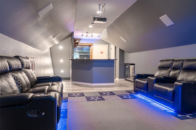 cinema room with baseboards and vaulted ceiling