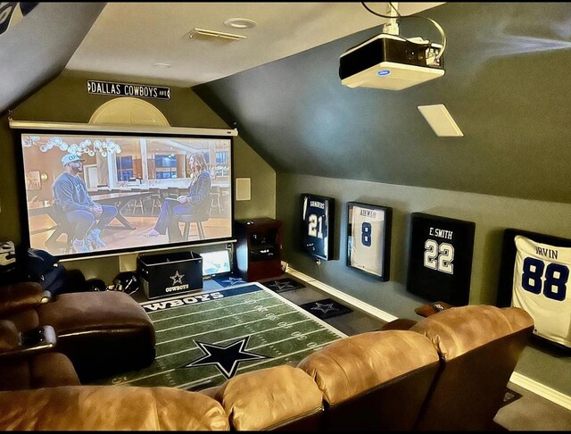 cinema with baseboards, vaulted ceiling, and visible vents