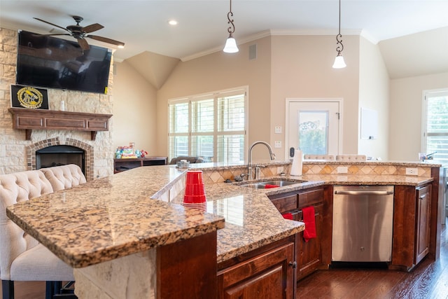 kitchen featuring a ceiling fan, dark wood-type flooring, a sink, dishwasher, and vaulted ceiling