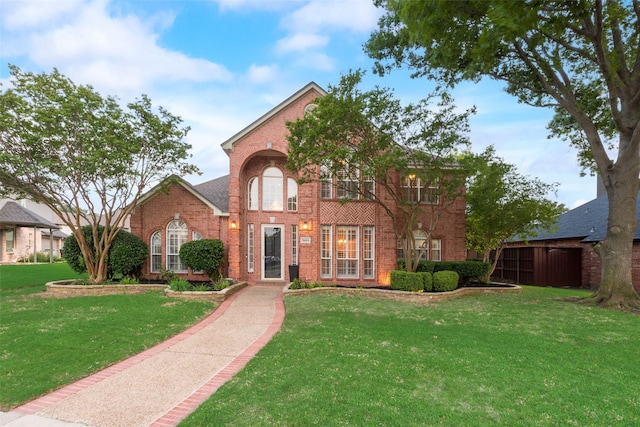 traditional home featuring brick siding and a front yard