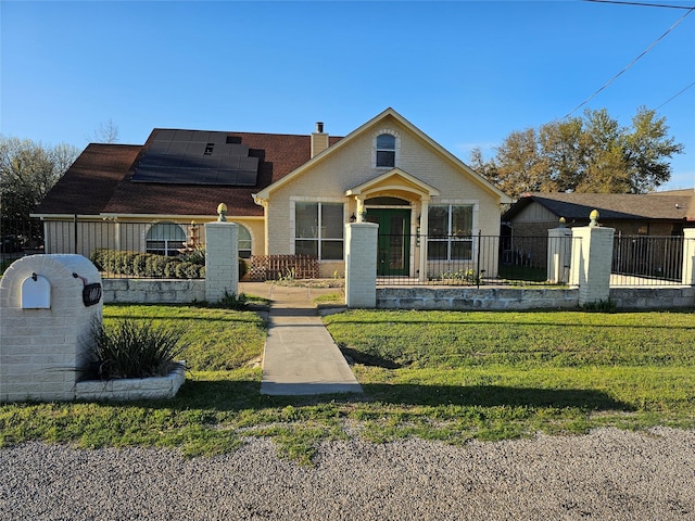 bungalow featuring a fenced front yard, a chimney, solar panels, and a front yard