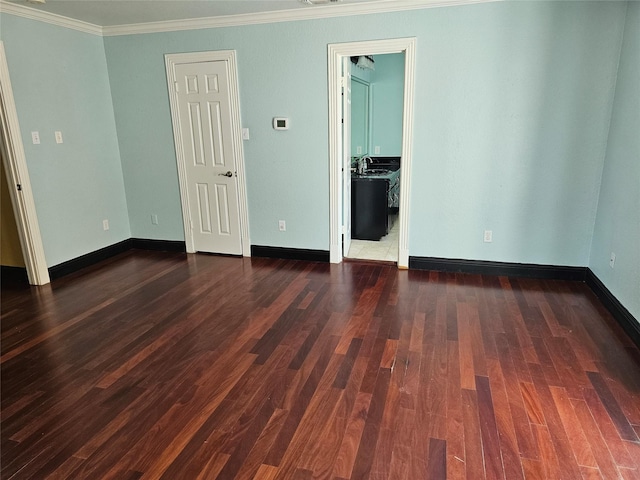 empty room featuring baseboards, dark wood finished floors, and ornamental molding