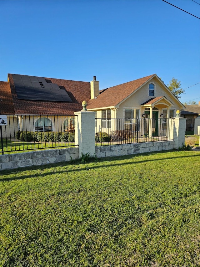 ranch-style home with a chimney, a fenced front yard, and a front lawn
