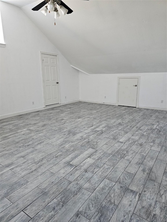additional living space featuring baseboards, ceiling fan, vaulted ceiling, and wood finished floors