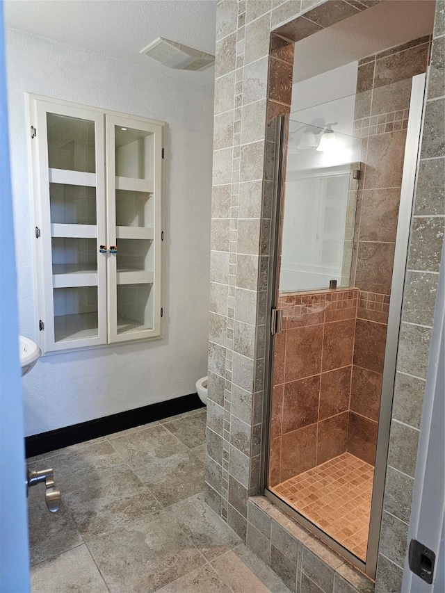 bathroom featuring toilet, visible vents, and a stall shower