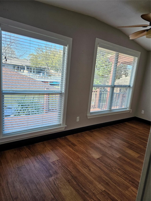 spare room with dark wood-style flooring, ceiling fan, and baseboards