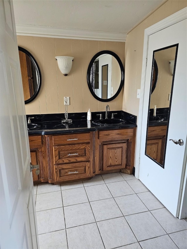 bathroom featuring crown molding, double vanity, tile patterned floors, and a sink