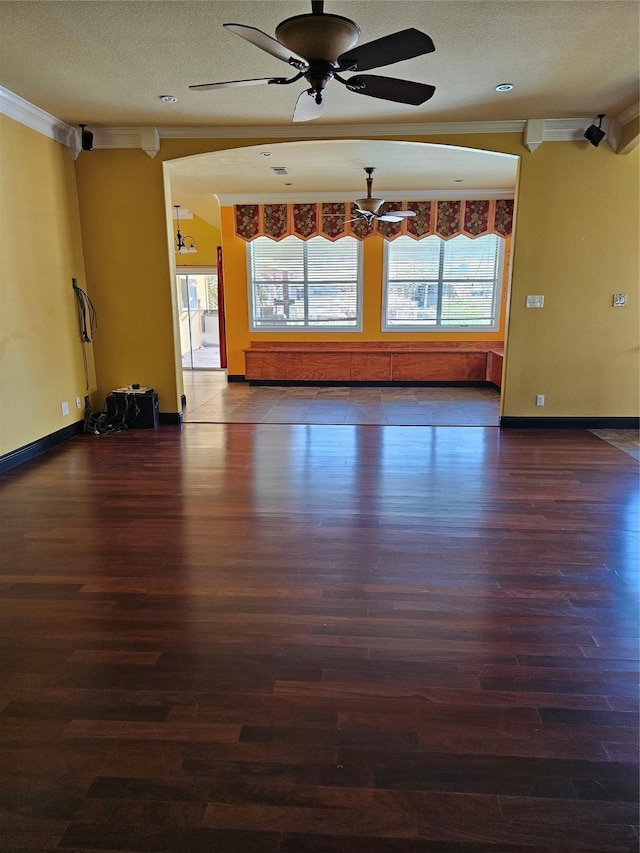 interior space with plenty of natural light, ornamental molding, a ceiling fan, and wood finished floors