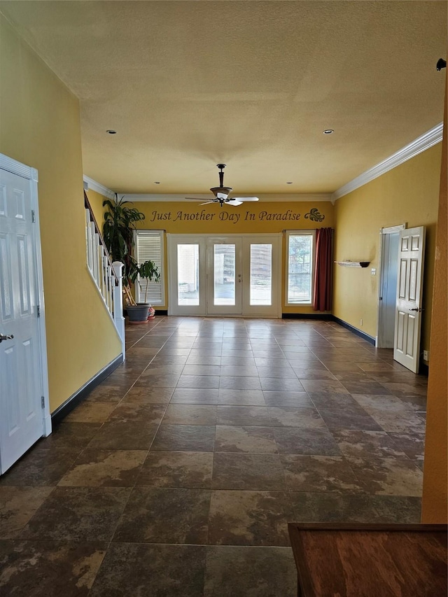 interior space with crown molding, ceiling fan, stairway, and a healthy amount of sunlight