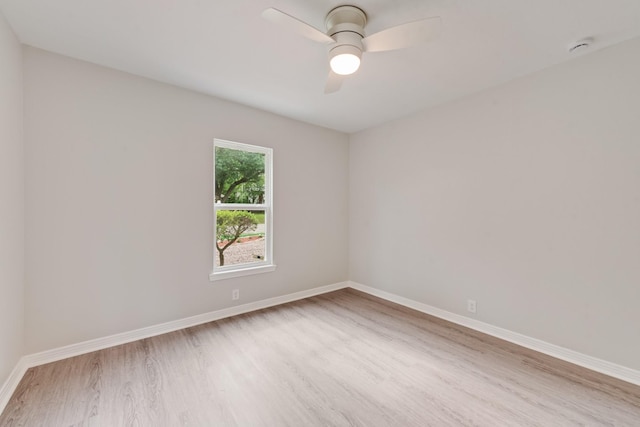 spare room featuring a ceiling fan, baseboards, and wood finished floors