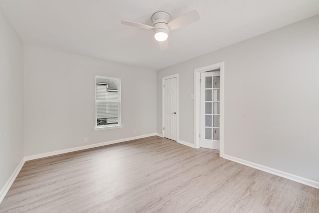spare room featuring baseboards, a ceiling fan, and wood finished floors