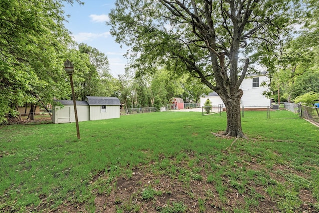 view of yard with a storage unit, a fenced backyard, and an outdoor structure