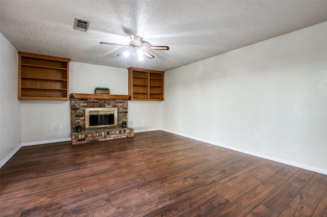 unfurnished living room featuring visible vents, baseboards, ceiling fan, dark wood-type flooring, and a textured ceiling