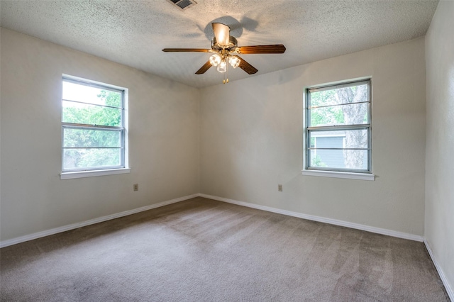 carpeted spare room with baseboards, ceiling fan, and a textured ceiling