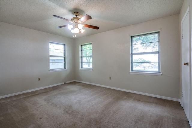 carpeted empty room featuring baseboards, a ceiling fan, and a textured ceiling