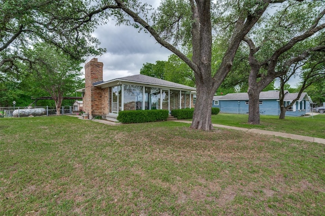 ranch-style house with a front lawn, fence, and a chimney