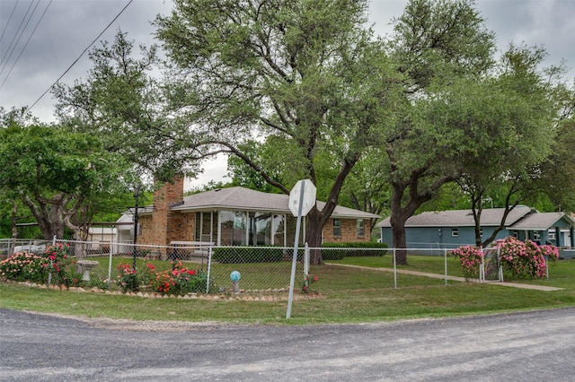 ranch-style home featuring a fenced front yard, a chimney, and a front yard