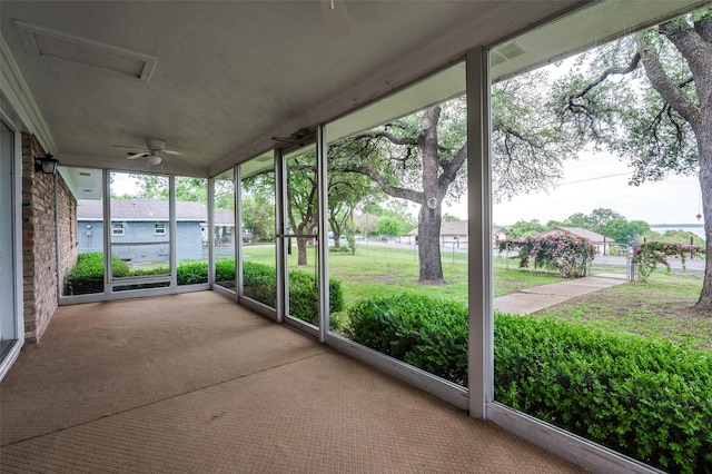 unfurnished sunroom featuring ceiling fan