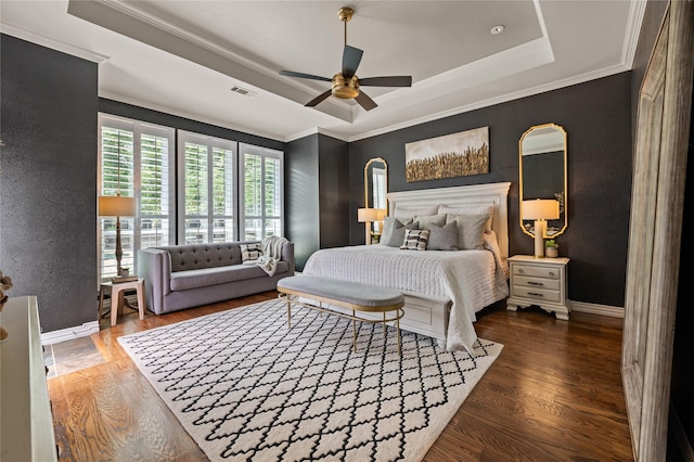 bedroom featuring visible vents, crown molding, wood finished floors, and a tray ceiling