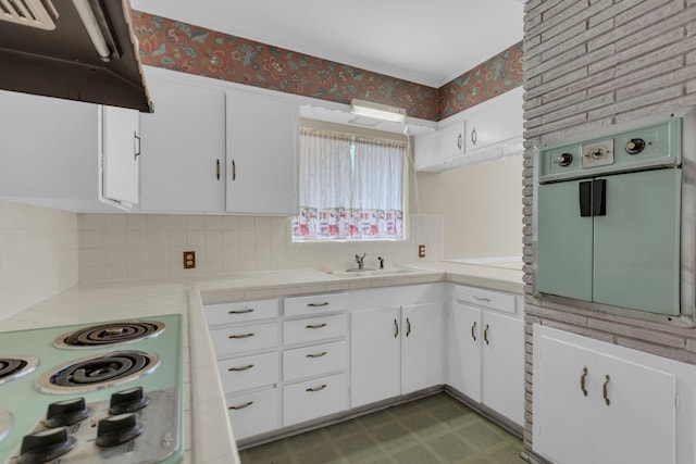 kitchen with white cabinets, extractor fan, wall oven, wallpapered walls, and light floors