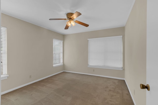 carpeted spare room with baseboards and ceiling fan