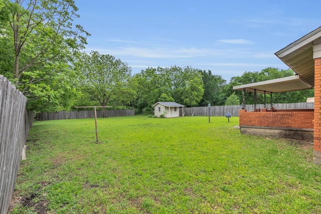 view of yard with a storage shed, an outbuilding, and a fenced backyard