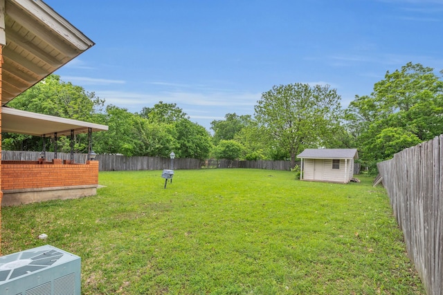 view of yard with a fenced backyard, a storage unit, and an outdoor structure