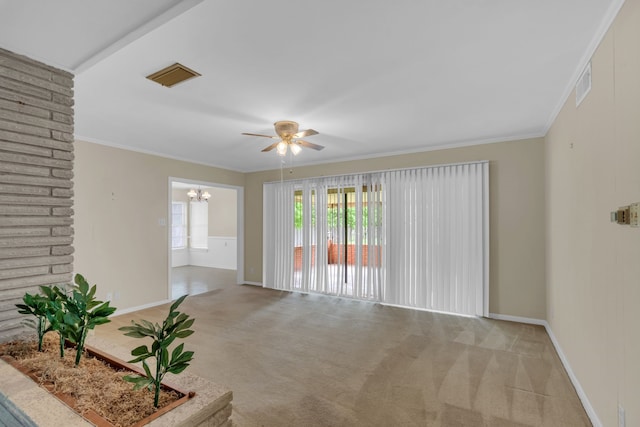 carpeted empty room featuring crown molding, baseboards, visible vents, and ceiling fan with notable chandelier
