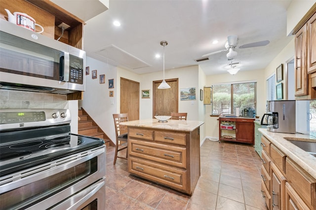 kitchen featuring appliances with stainless steel finishes, ceiling fan, light stone countertops, and visible vents