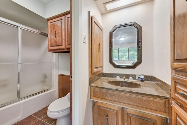 bathroom with tile patterned flooring, enclosed tub / shower combo, toilet, and vanity