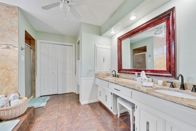 bathroom featuring double vanity, a sink, a ceiling fan, and a shower stall