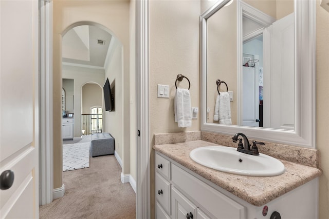 bathroom with crown molding, vanity, and baseboards