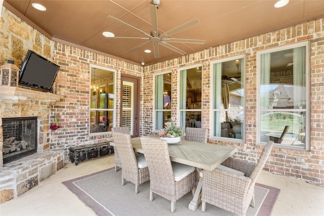 view of patio / terrace featuring an outdoor stone fireplace, a ceiling fan, and outdoor dining space