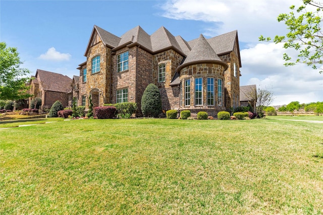 view of front facade with a front lawn, brick siding, and stone siding