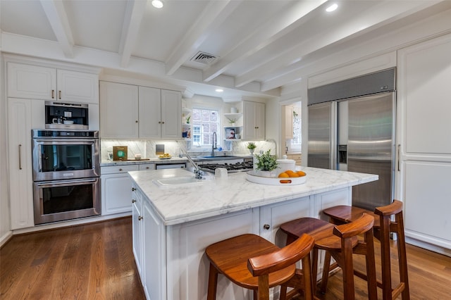 3400 Shenandoah St, University Park, TX 75205 - kitchen with appliances with stainless steel finishes, visible vents, a sink, backsplash, and beam ceiling