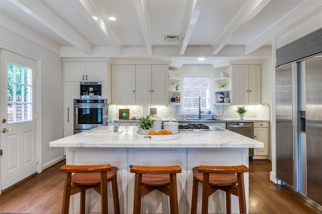 3400 Shenandoah St, University Park, TX 75205 - kitchen with open shelves, dark wood finished floors, backsplash, beamed ceiling, and appliances with stainless steel finishes