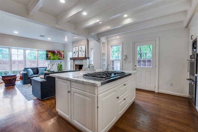 3400 Shenandoah St, University Park, TX 75205 - kitchen with stainless steel appliances, a fireplace, open floor plan, dark wood finished floors, and beamed ceiling