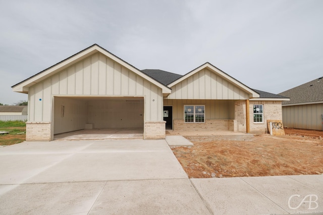 3832 National Dr, Abilene, TX 79602 - view of front of house with brick siding, driveway, board and batten siding, and an attached garage